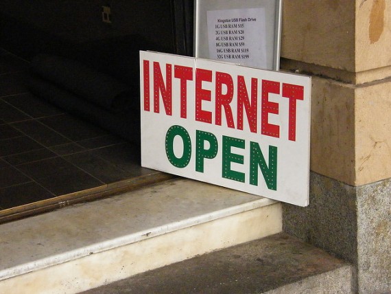 Uma placa de internet open em vermelho e verde encostada no batente de uma janela
