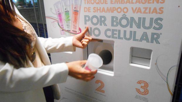 Consumidora deposita utiliza máquina que troca embalagens vazias por créditos para celular