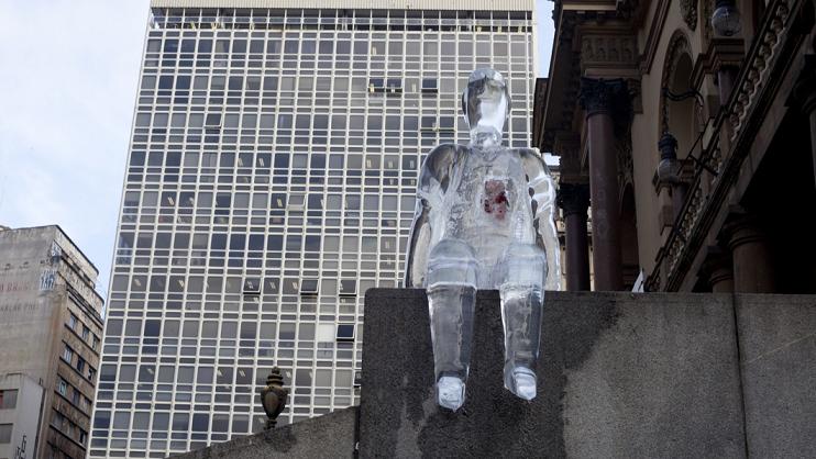 Escultura feita de gelo mostra um homem sentado, com destaque para o coração
