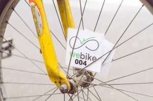 Close de adesivo com os dizeres "WeBike 004" dentro da parte interna da roda de uma bicicleta.