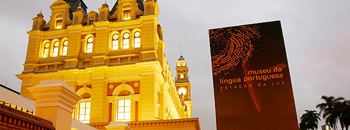Foto mostra a fachada do Museu da Língua Portuguesa, que fica no prédio da Estação da Luz. Do lado direito da imagem, há uma placa com os dizeres "Museu da Língua Portuguesa - Estação da Luz"